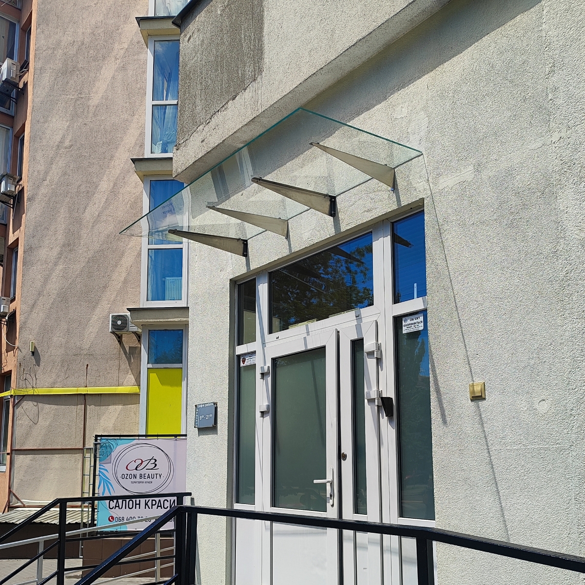 Стеклянный навес над входом в магазин из прозрачного стекла на кронштейнах — Faenza