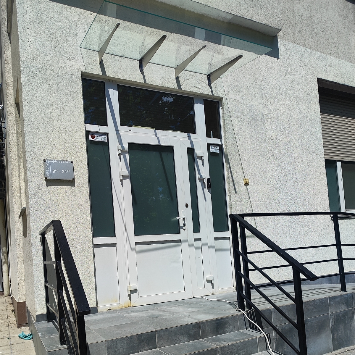 Стеклянный навес над входом в магазин из прозрачного стекла на кронштейнах — Faenza