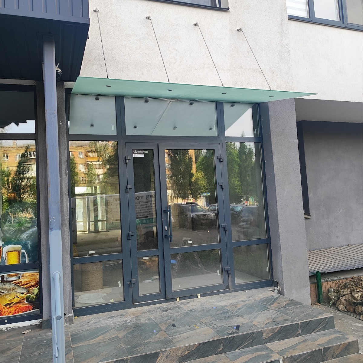 Стеклянный навес над входом в магазин из матового стекла на вантах — Lugo