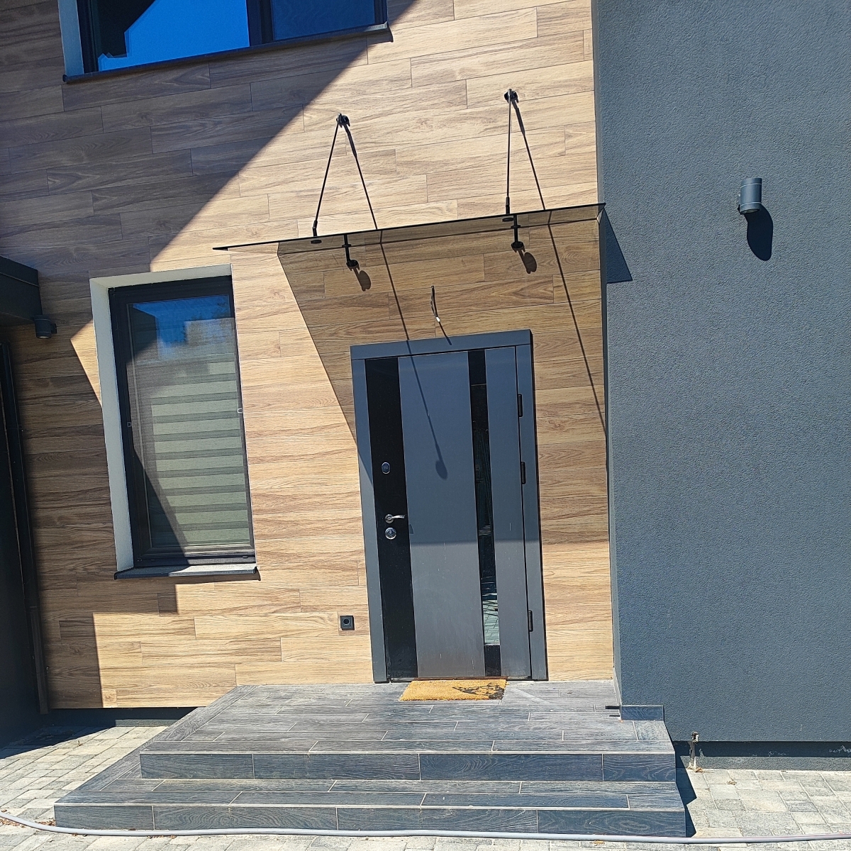 Стеклянный навес над входом из графитового стекла на чёрных матовых вантах — Calitri