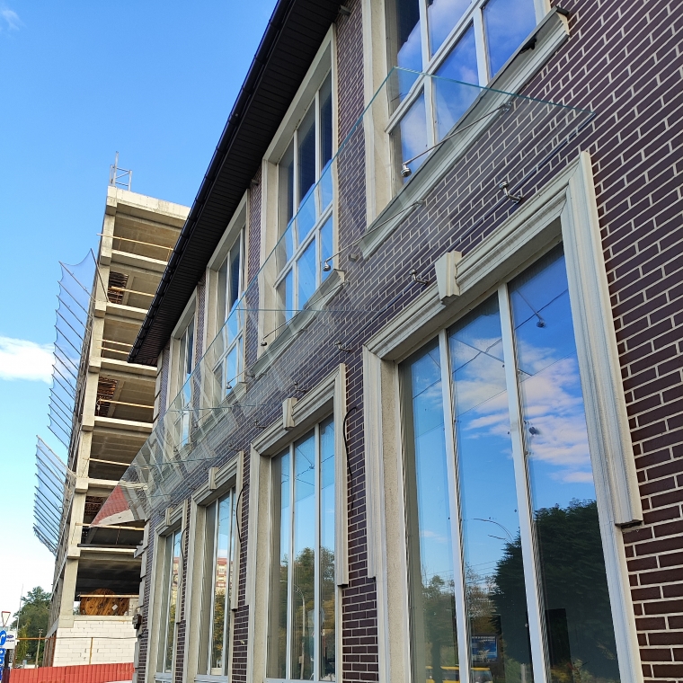 Стеклянный навес для коммерческого помещения «Новая Почта» из триплекса 6.16 на вантах длиной 10 м — Ravenna Стеклянный навес для коммерческого помещения «Новая Почта» из триплекса 6.16 на вантах длиной 10 м — Ravenna