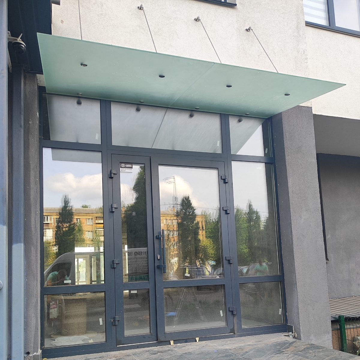 Стеклянный навес над входом в магазин из матового стекла на вантах — Lugo