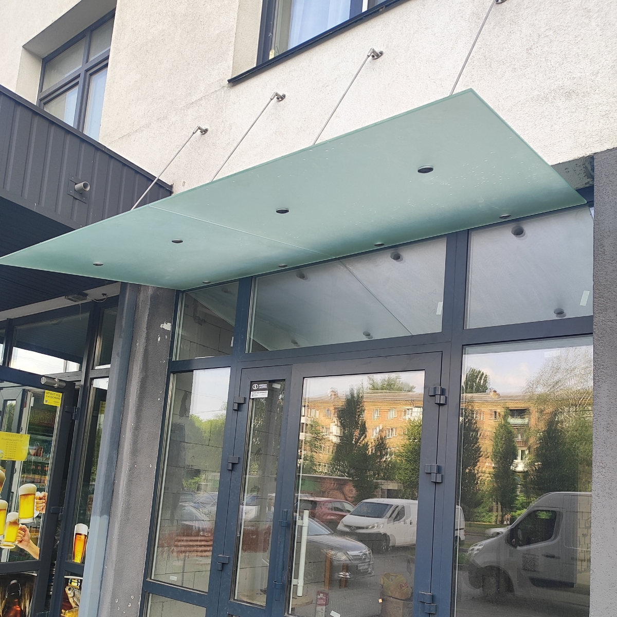 Стеклянный навес над входом в магазин из матового стекла на вантах — Lugo