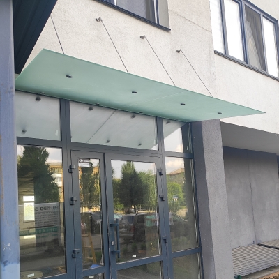 Стеклянный навес над входом в магазин из матового стекла на вантах — Lugo