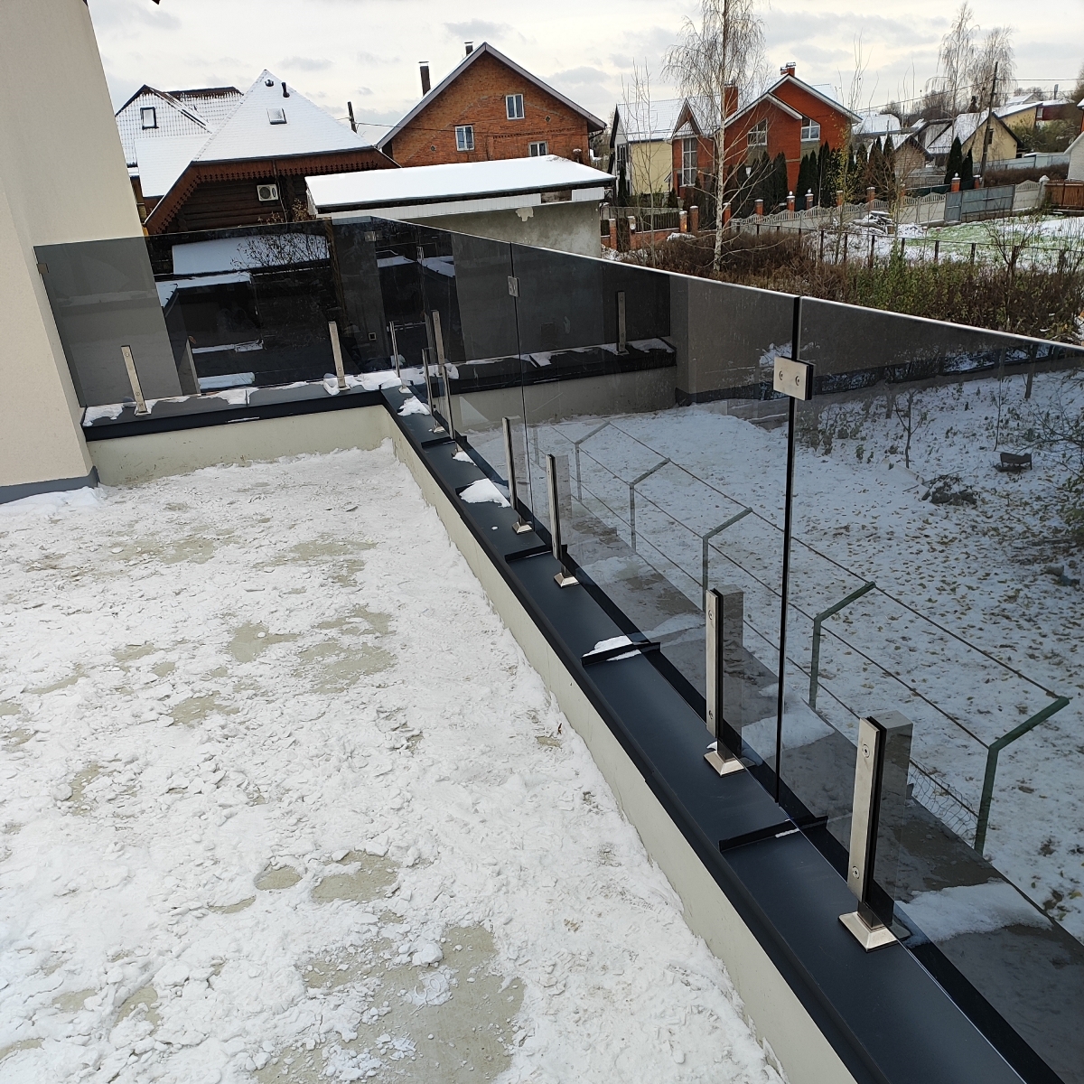 Скляне огородження тераси з графітового скла на парапеті з нержавіючими стійками